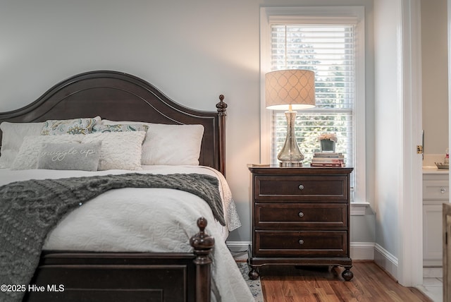 bedroom featuring baseboards and wood finished floors