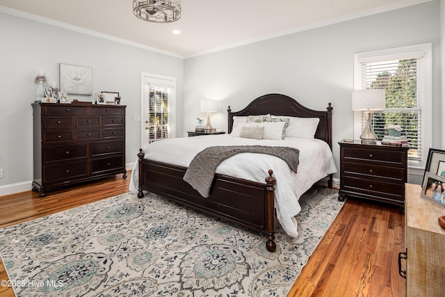 bedroom with recessed lighting, wood finished floors, baseboards, and ornamental molding