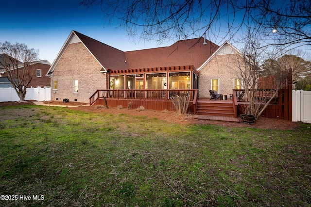 back of property with brick siding, a lawn, and fence private yard