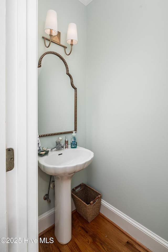 bathroom with wood finished floors, baseboards, and a sink