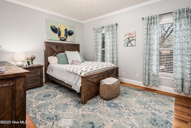 bedroom with baseboards, wood finished floors, and ornamental molding