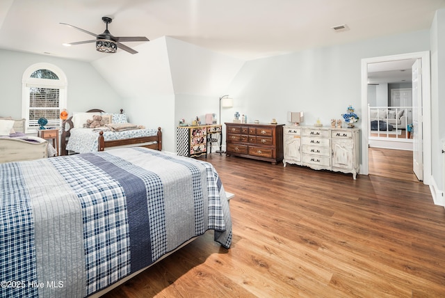 bedroom featuring vaulted ceiling, a ceiling fan, visible vents, and wood finished floors