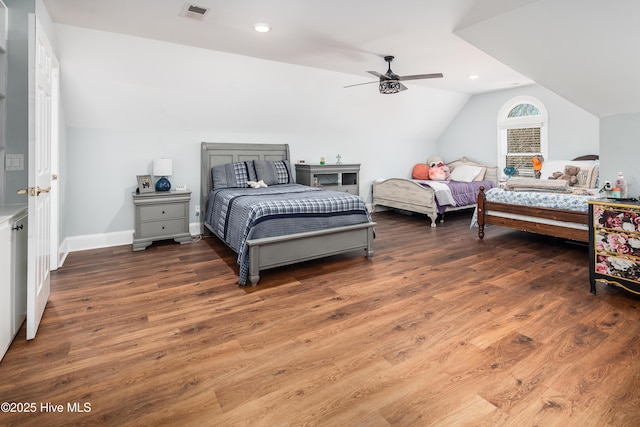 bedroom with ceiling fan, visible vents, lofted ceiling, and wood finished floors