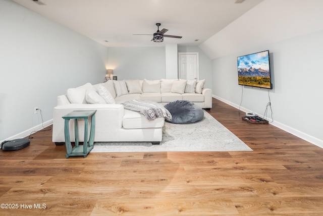 living area with baseboards, wood finished floors, lofted ceiling, and ceiling fan