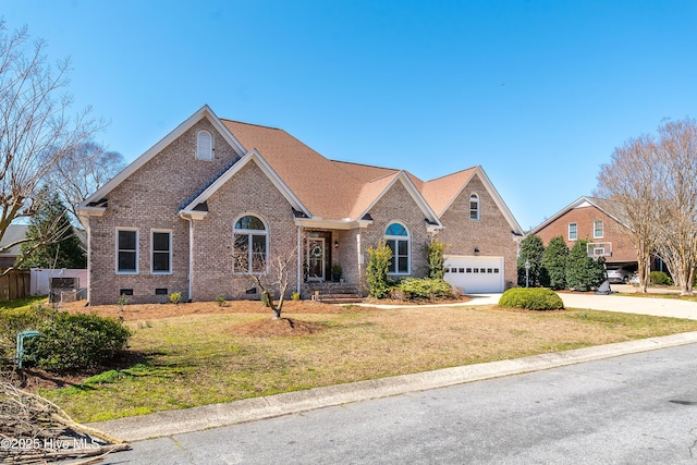 view of front of property featuring a front yard, fence, driveway, crawl space, and brick siding