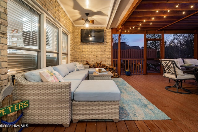 interior space featuring beam ceiling, brick wall, a ceiling fan, and wood-type flooring