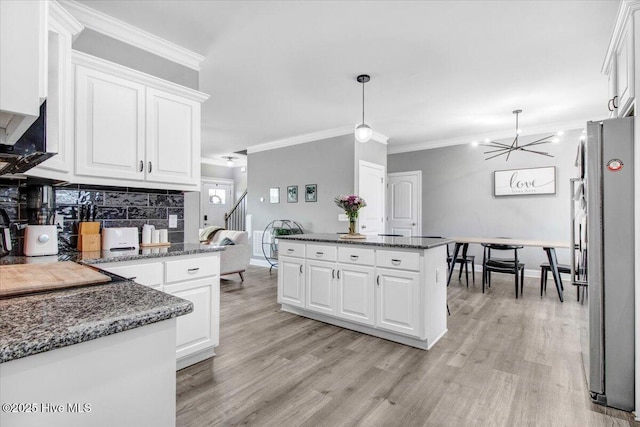 kitchen with white cabinetry, light wood-style flooring, and freestanding refrigerator