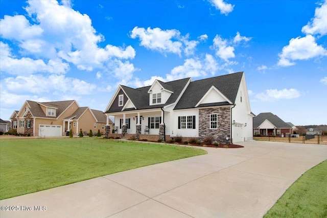 view of front of house featuring a front lawn, stone siding, a porch, concrete driveway, and an attached garage