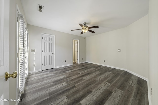 unfurnished bedroom featuring visible vents, dark wood-style floors, baseboards, and ceiling fan