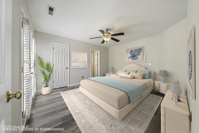 bedroom with visible vents, a ceiling fan, baseboards, and wood finished floors