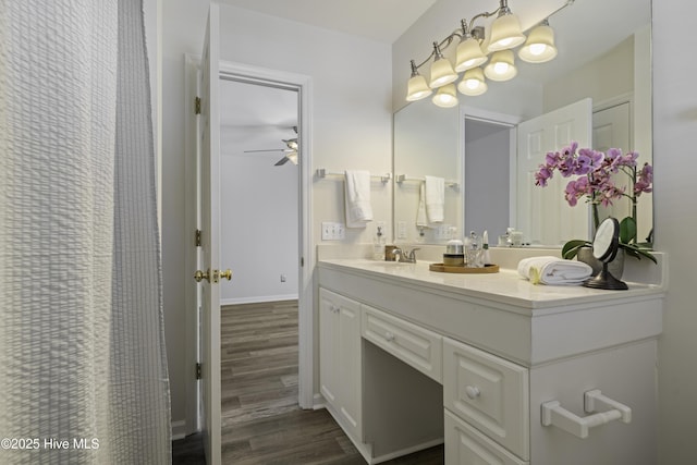 full bathroom featuring vanity, wood finished floors, baseboards, and ceiling fan