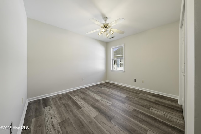 empty room with dark wood finished floors, visible vents, baseboards, and ceiling fan