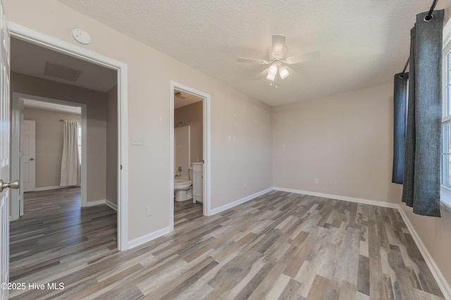 83 Crush Ct, Swansboro, NC 28584 - unfurnished bedroom featuring light wood-style flooring, a textured ceiling, baseboards, ensuite bathroom, and a ceiling fan