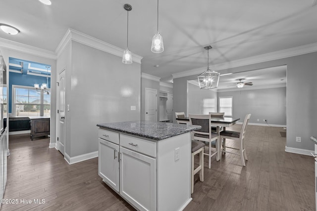 kitchen with a wealth of natural light, dark wood-type flooring, and a kitchen island