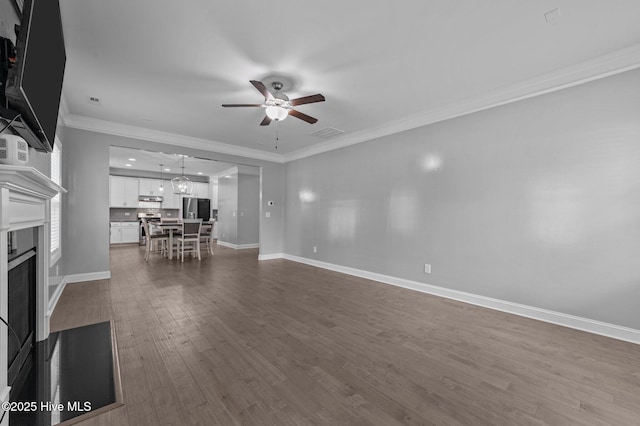 unfurnished living room with visible vents, a fireplace, ceiling fan, ornamental molding, and dark wood-type flooring