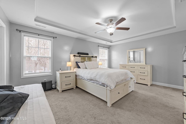 bedroom with visible vents, light colored carpet, baseboards, and a tray ceiling