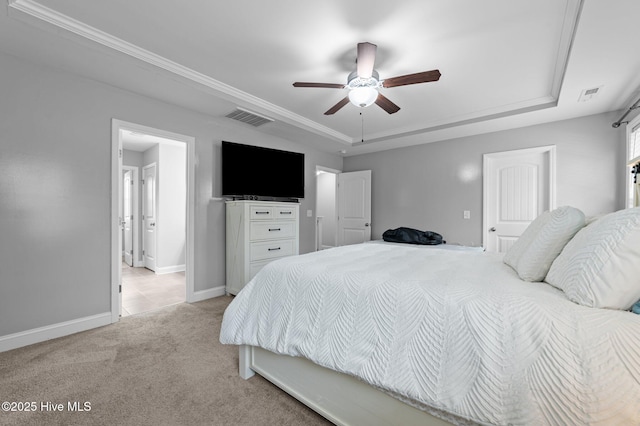 bedroom with a raised ceiling, baseboards, visible vents, and light carpet