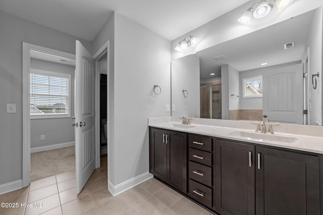 full bath with a sink, a wealth of natural light, and double vanity