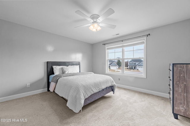 carpeted bedroom with visible vents, a ceiling fan, and baseboards