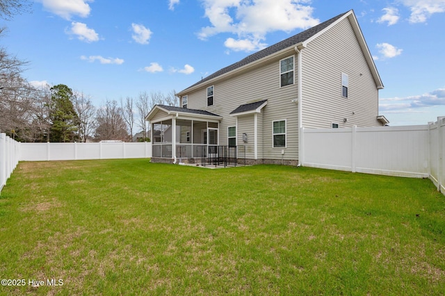 back of property with a fenced backyard, a yard, and a sunroom