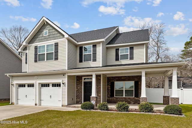 craftsman inspired home featuring a front lawn, driveway, fence, covered porch, and brick siding