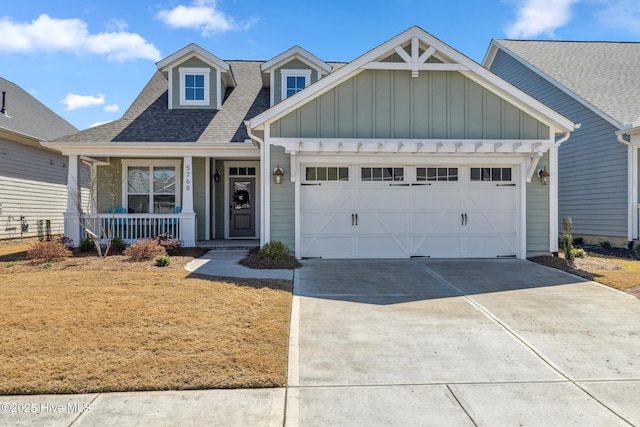 view of front of house featuring board and batten siding, a shingled roof, a porch, driveway, and an attached garage