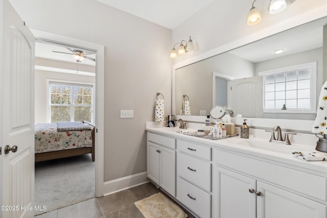 bathroom with baseboards, double vanity, ceiling fan, a sink, and tile patterned floors