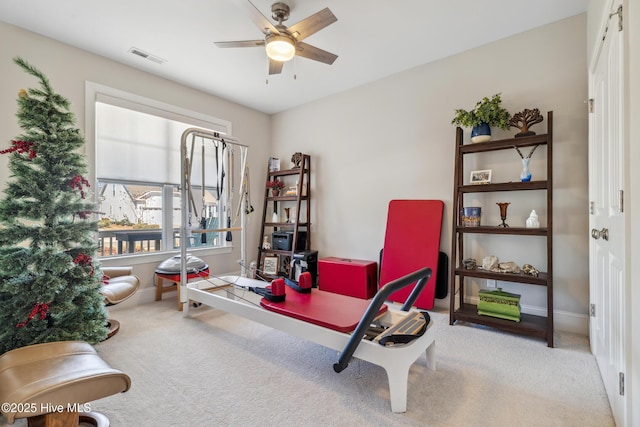 interior space featuring carpet flooring, a ceiling fan, visible vents, and baseboards