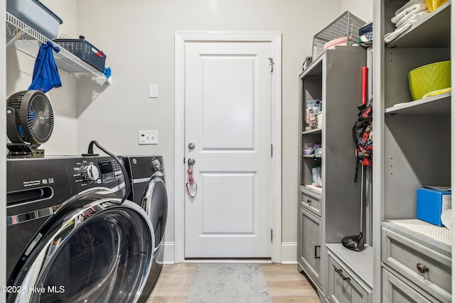 laundry room featuring washing machine and clothes dryer, laundry area, and light wood-type flooring