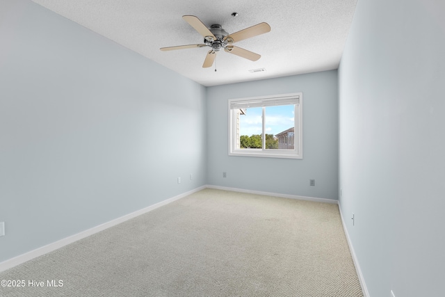 unfurnished room featuring a textured ceiling, baseboards, light carpet, and ceiling fan