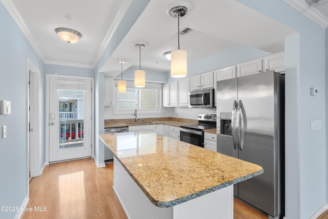 kitchen with visible vents, a sink, ornamental molding, stainless steel appliances, and white cabinetry