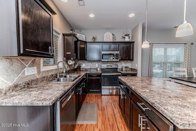 kitchen with visible vents, backsplash, light wood-style floors, stainless steel appliances, and a sink