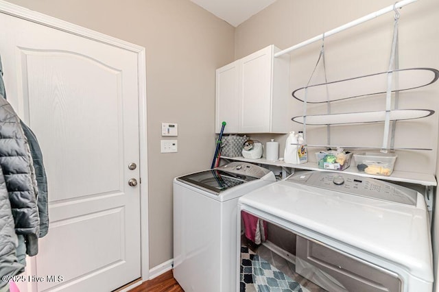 laundry room featuring washing machine and dryer, cabinet space, and baseboards