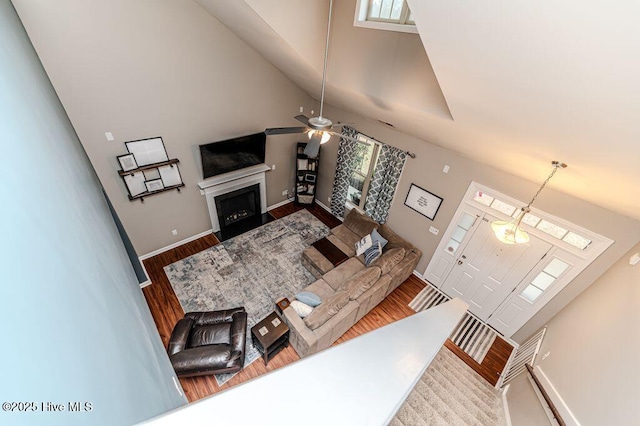 living room with baseboards, a fireplace with flush hearth, and wood finished floors