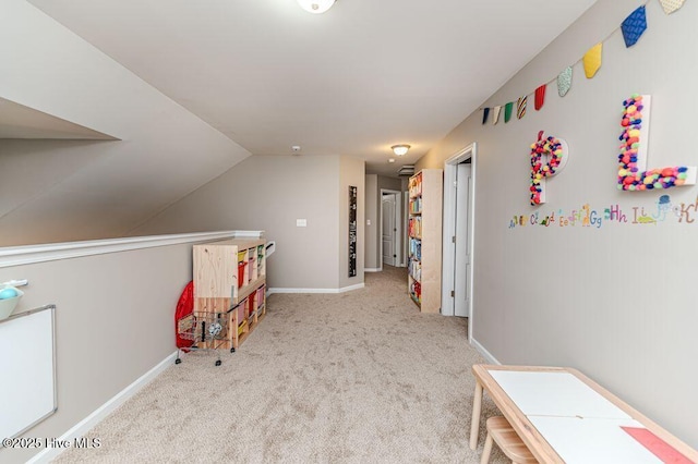 recreation room with carpet flooring, baseboards, and vaulted ceiling