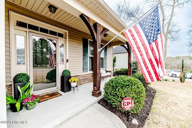 doorway to property featuring stone siding and covered porch