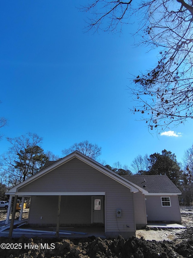 exterior space featuring roof with shingles