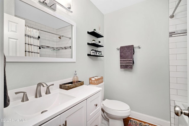 full bathroom featuring baseboards, toilet, vanity, and a tile shower