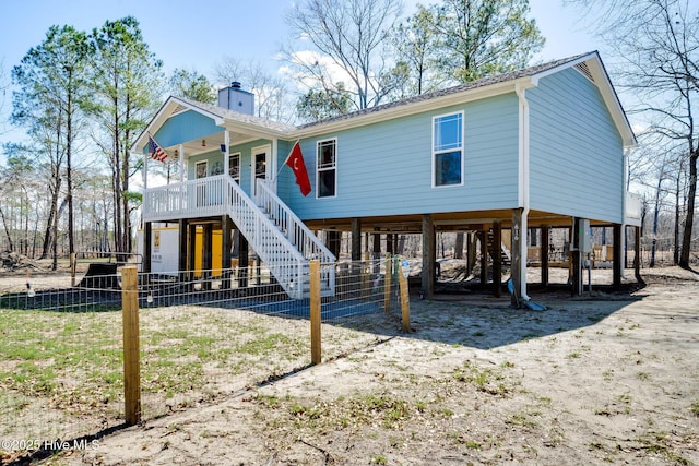 view of front of home featuring a carport, a chimney, and stairs