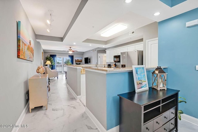 kitchen featuring visible vents, marble finish floor, stainless steel refrigerator with ice dispenser, black microwave, and baseboards