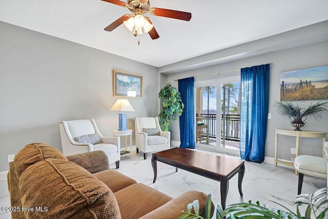 living area with marble finish floor, baseboards, and ceiling fan