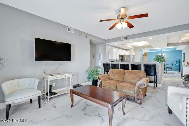 living area featuring a ceiling fan, visible vents, baseboards, recessed lighting, and marble finish floor