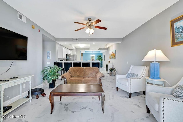 living area with visible vents, marble finish floor, and ceiling fan