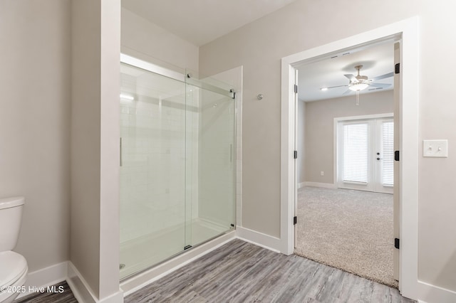 full bathroom featuring a shower stall, toilet, and baseboards