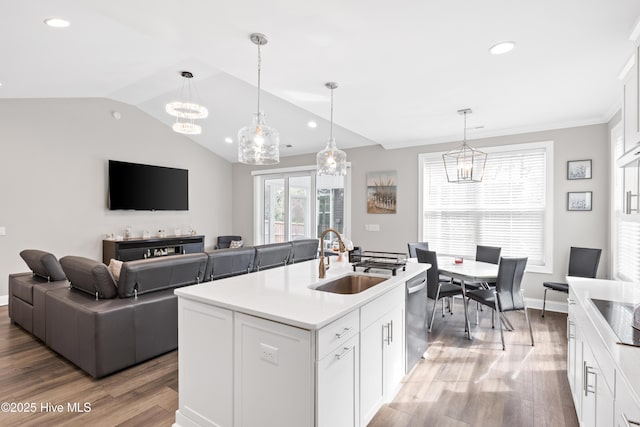 kitchen featuring an inviting chandelier, light wood-style flooring, a sink, vaulted ceiling, and stainless steel dishwasher