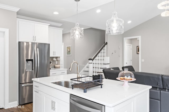 kitchen featuring a sink, an island with sink, ornamental molding, appliances with stainless steel finishes, and dark wood-style flooring