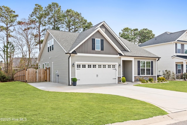 craftsman-style house with board and batten siding, a shingled roof, a front yard, a garage, and driveway