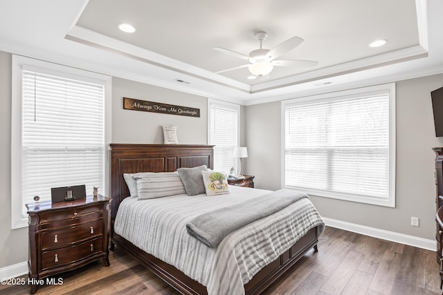 bedroom with visible vents, a raised ceiling, and wood finished floors