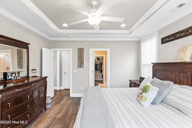 bedroom featuring a raised ceiling, wood finished floors, visible vents, and ornamental molding