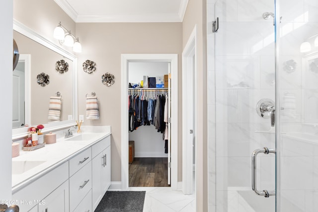 full bath with a sink, double vanity, a stall shower, and crown molding